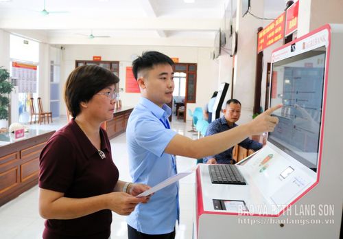 Cán bộ Trung tâm Phục vụ hành chính công xã Thất Khê hướng dẫn người dân sử dụng "Trạm Dịch vụ công số" thực hiện thủ tục hành chính