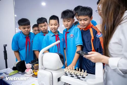 Tại một gian hàng, những ván cờ vua diễn ra giữa người chơi và một đối thủ đặc biệt: robot chơi cờ ứng dụng AI. Tại đây, những màn "đấu trí" đầy cam go và thú vị khi các em có cơ hội trực tiếp so tài với một đối thủ không phải con người. (Ảnh: Minh Sơn/Vietnam+)