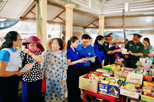 Cán bộ Lữ đoàn 683 và đoàn viên địa phương phát tài liệu, tuyên truyền pháp luật tới người dân. Ảnh: Nguyễn Lựu