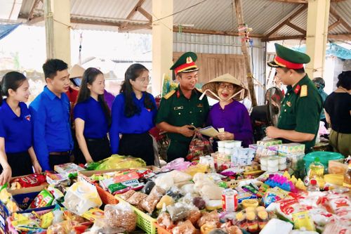 Cán bộ Lữ đoàn 683 và đoàn viên địa phương phát tài liệu, tuyên truyền pháp luật tới người dân. Ảnh: Nguyễn Lựu