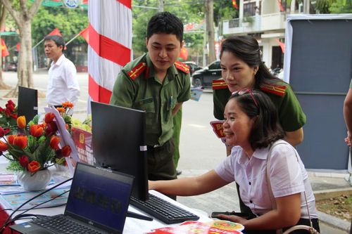Lực lượng Công an hướng dẫn người dân thao tác trên cổng dịch vụ công. (Ảnh: HOÀNG TÍNH)