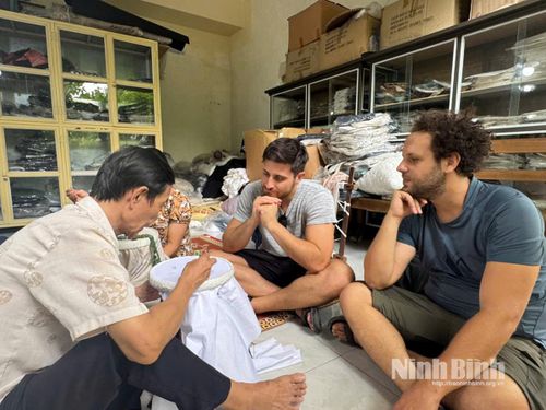 Du khách hào hứng khi trải nghiệm thêu ren do chính nghệ nhân Vũ Thanh Luân hướng dẫn.
