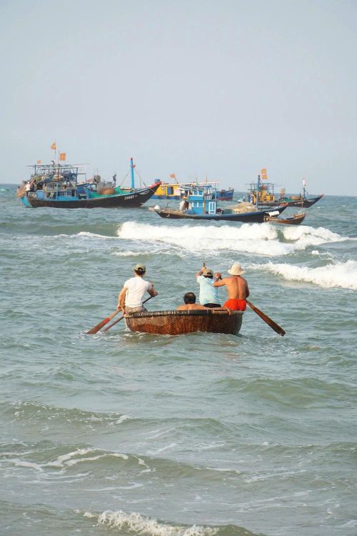 Những người đàn ông làng biển chèo thúng chai tiếp cận tàu đánh bắt, trung chuyển hải sản vào bờ