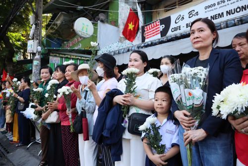  Em Thiên Ân, học sinh lớp 1/1 Trường Tiểu học Đặng Thùy Trâm, cùng mẹ đến Công viên Lê Thị Riêng để tiễn đưa các liệt sĩ. Ảnh: HOÀNG TRIỀU 