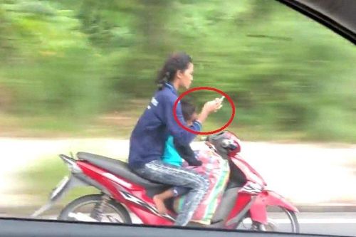 Clip: Phụ nữ đi xe máy đèo trẻ nhỏ, buông cả 2 tay nhắn tin gây sốc