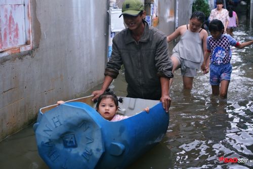 Mưa ngập lịch sử ở TP.HCM: Người dân kết bè thả ra đường, thích thú túm tụm chụp ảnh vui chơi giữa biển nước
