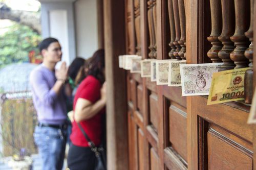 Nhét kín tiền lẻ vào khe cửa trước đền, chùa ngày đầu năm