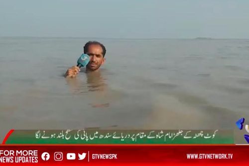 Phóng viên Pakistan đưa tin trong dòng nước lũ ngập đến cằm