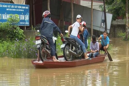 Bi hài mùa lũ: Chèo thuyền chở xe máy qua quốc lộ bị ngập