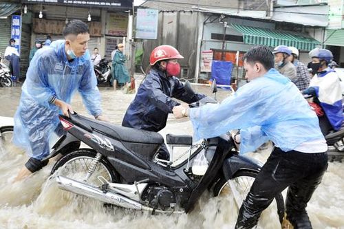 Giúp dân qua đường ngập nước