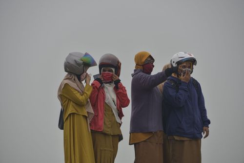 Người đeo khẩu trang, máy bay lăn bánh giữa bụi mù cháy rừng Indonesia