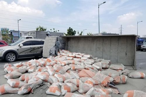 Lật xe tải, hàng chục bao xi măng đổ tràn ra đường