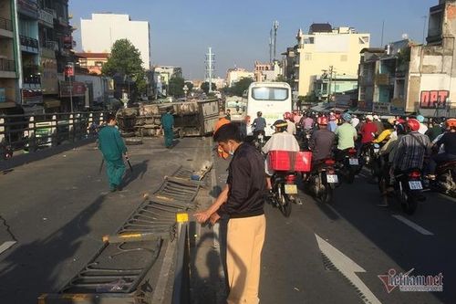 Xe tải lật trúng 2 xe máy, ép cô gái kẹt cứng vào thành cầu ở Sài Gòn