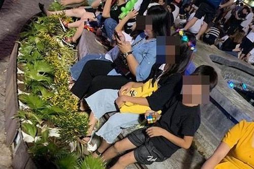Bức xúc hình ảnh hàng chục người ngồi bên đài phun nước phố đi bộ Hồ Gươm, thản nhiên đạp chân thẳng lên hàng hoa trang trí