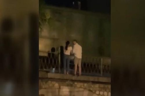 Đôi nam nữ đứng sát đường ray trên phố Phùng Hưng ngắm tàu