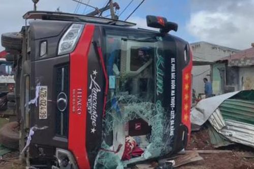 Sau tiếng phanh gấp, xe khách lật đè sập tường rào nhà dân