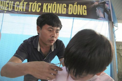 Học sinh nghèo thích thú với tiệm cắt tóc 0 đồng tại trường của thầy giáo