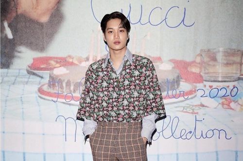 Kai mặc áo hoa, tạo dáng trên nền chữ nguệch ngoạc của Gucci