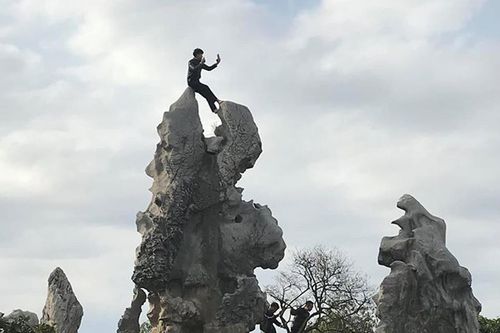 Nam thanh niên bất chấp trèo lên đỉnh đá của chùa chỉ để 'sống ảo' gây bức xúc