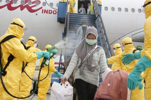 Người Indonesia về từ Vũ Hán bị phun thuốc khử trùng tại chân máy bay