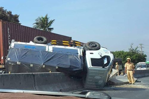 Ôtô tải lật ngửa trên dải phân cách sau khi vượt xe đầu kéo