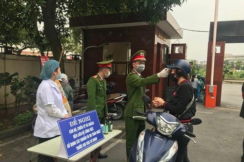 Công an Long Biên kiểm tra thân nhiệt, phát khẩu trang miễn phí cho cán bộ, người dân đến làm việc
