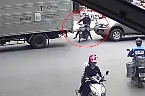 Xe máy cố sang đường bị ô tô đâm trúng, ép kẹt vào đuôi xe tải
