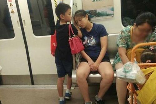 Thấy mẹ ngủ gật trên tàu, cậu bé đã xách hết đồ rồi làm hành động này khiến ai nấy đều thấy ấm lòng