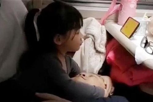 Thấy bố mệt mỏi khi đi tàu, bé gái giúp trông hành lý rồi làm hành động được bao người khen ngợi