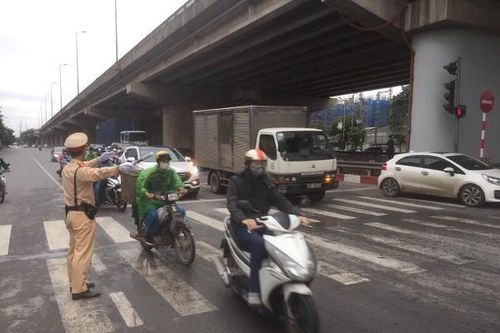 Cảnh sát giao thông căng mình phân luồng trong sáng sớm ngày đầu nới lỏng giãn cách xã hội ở Hà Nội