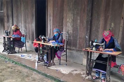 Phụ nữ dân tộc Mông ở Mù Cang Chải may khẩu trang tại nhà chống dịch COVID-19