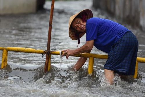 Mưa tối trời 30 phút, dân Sài Gòn móc cống dọn rác, dìu nhau qua đường ngập