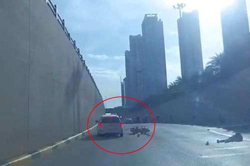 Ô tô đánh lái gấp tránh người phụ nữ đi xe máy tự ngã dưới hầm chui