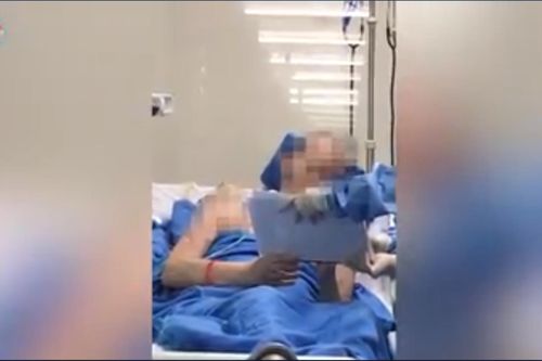 Phi công người Anh cầm bút viết lên bảng, ngồi xe lăn phơi nắng