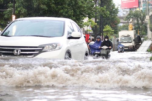 Đường Nguyễn Hữu Cảnh lại ngập, dân lấy tấm ván be cửa ngăn nước tràn vào nhà