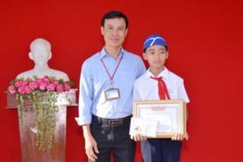 Cậu học sinh đội mưa dọn rác ở cống nước trên đường đi học về được biểu dương, khen thưởng trước toàn trường
