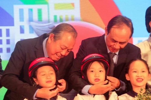Cha mẹ chở con đầu trần đi qua trước mặt lực lượng tuần tra mà không bị xử phạt