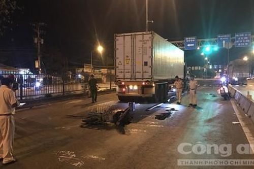 Chạy xe máy trong làn ô tô rồi ngã vào gầm container, 2 người thương vong