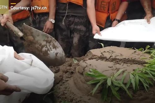 Binh sĩ Trung Quốc nhận bánh sinh nhật bằng bùn giữa lúc vật lộn chống lũ