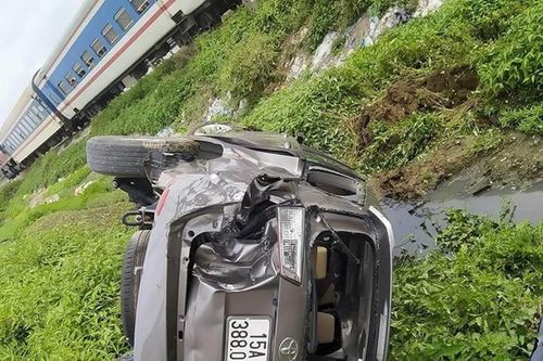 Cố vượt đường tàu, xe Innova ngửa bụng nằm dưới ruộng