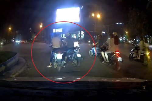 Hai người phụ nữ dừng xe máy để tâm sự giữa ngã năm