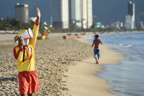 Bãi biển Đà Nẵng vắng vẻ, người dân đeo khẩu trang tập thể dục