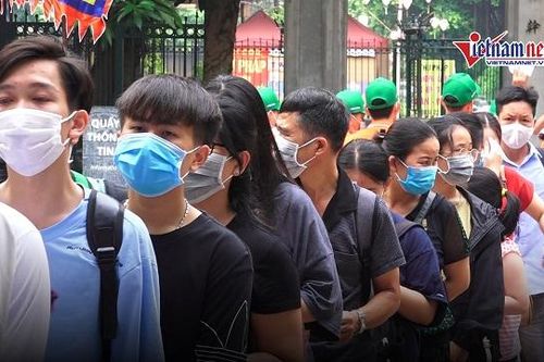Du khách đeo khẩu trang xếp hàng rửa tay, đo thân nhiệt tại Hà Nội