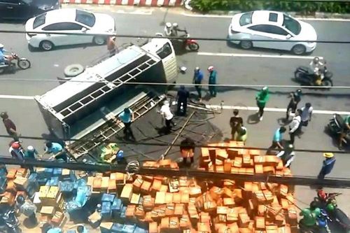 Người dân giúp tài xế gom hàng trăm thùng nước ngọt đổ ra đường