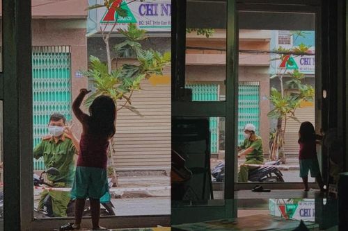 Khoảnh khắc chiến sĩ công an nhìn con gái nhỏ qua lớp cửa kính, cô bé đưa tay ra hiệu 'ok' với ba gây xúc động