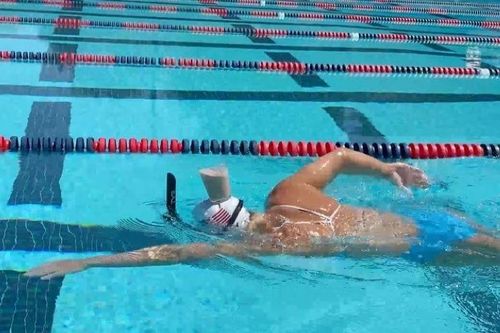 Xem vận động viên Olympic giữ thăng bằng cốc sữa trên đầu khi bơi