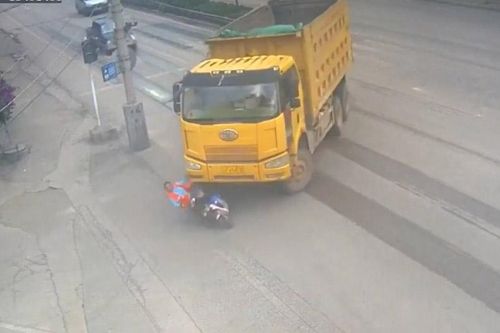 Bị xe tải 'nuốt chửng', người phụ nữ đi xe điện thoát chết kỳ diệu