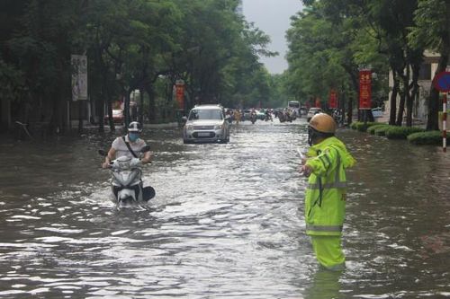 Cảnh sát giao thông dầm mình trong mưa lớn, đường ngập để phân luồng chống ùn tắc
