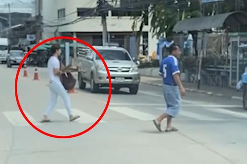 Chàng trai Thái bế người khuyết tật qua đường