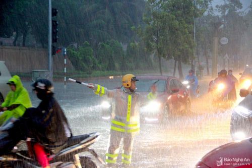 Cảnh sát giao thông Thành phố Vinh dầm mưa điều tiết phương tiện trên các tuyến đường ngập sâu